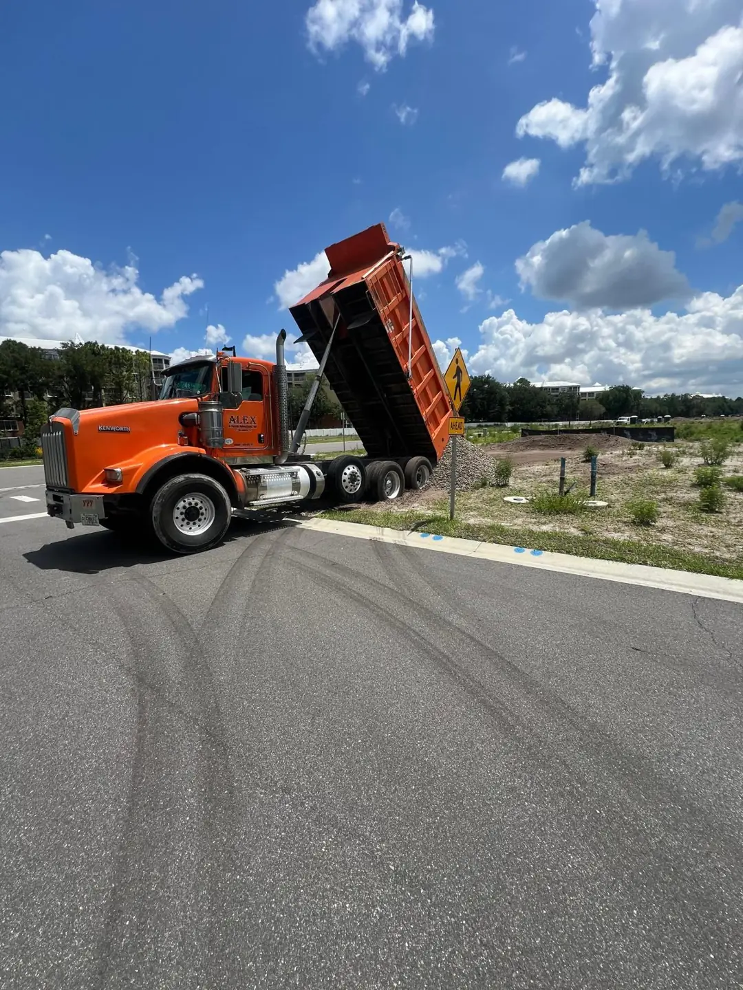 Alex and Family Kenworth dump truck delivering gravel at an Orlando job site