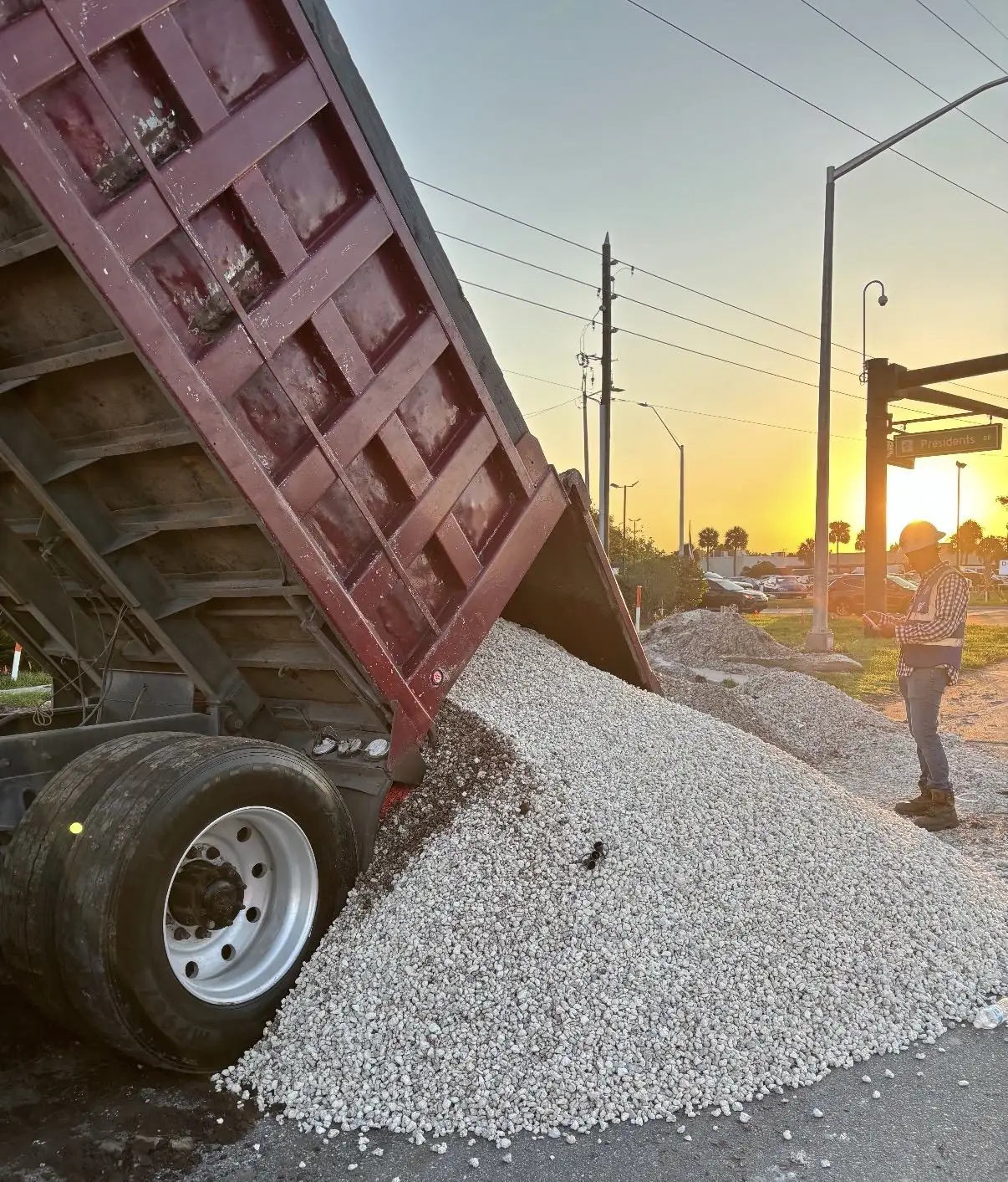 Alex and Family dump truck unloading crushed stone at an Orlando job site